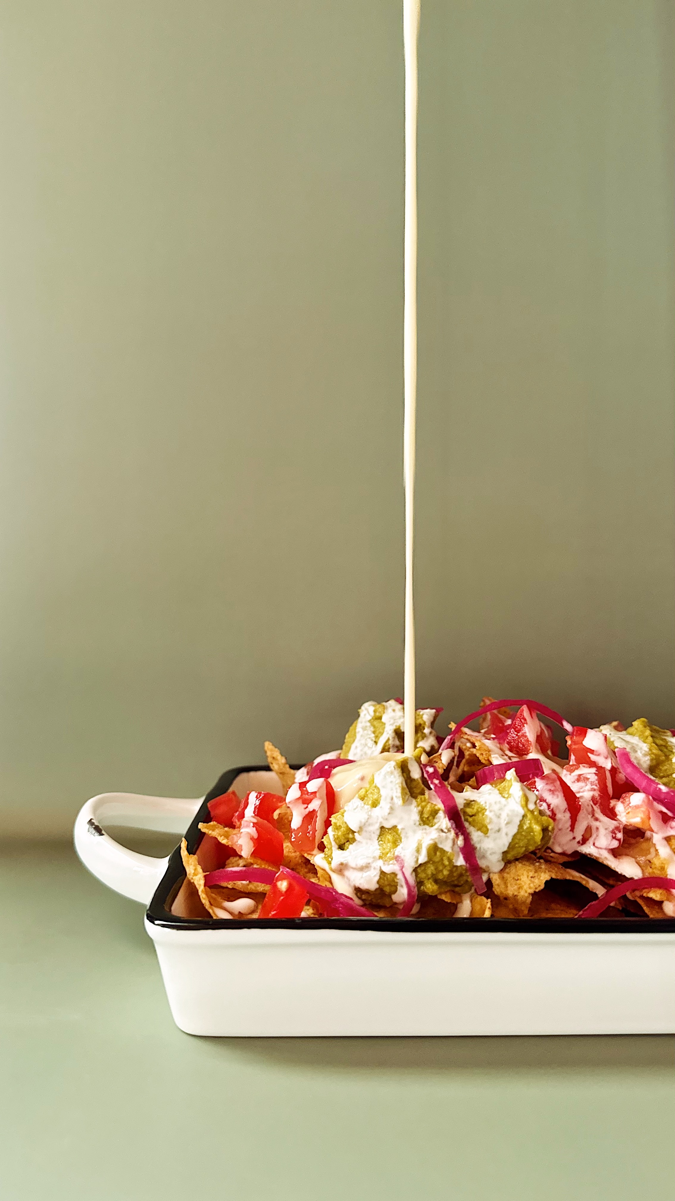 Plat de nachos, guacamole, pickles d'oignions rouges, sauce salsa, picko de galo, crème fraîche, sauce fromagère